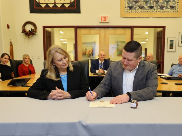 President Dr. Pamela L. Alderman and Kyle Utter signing agreement.